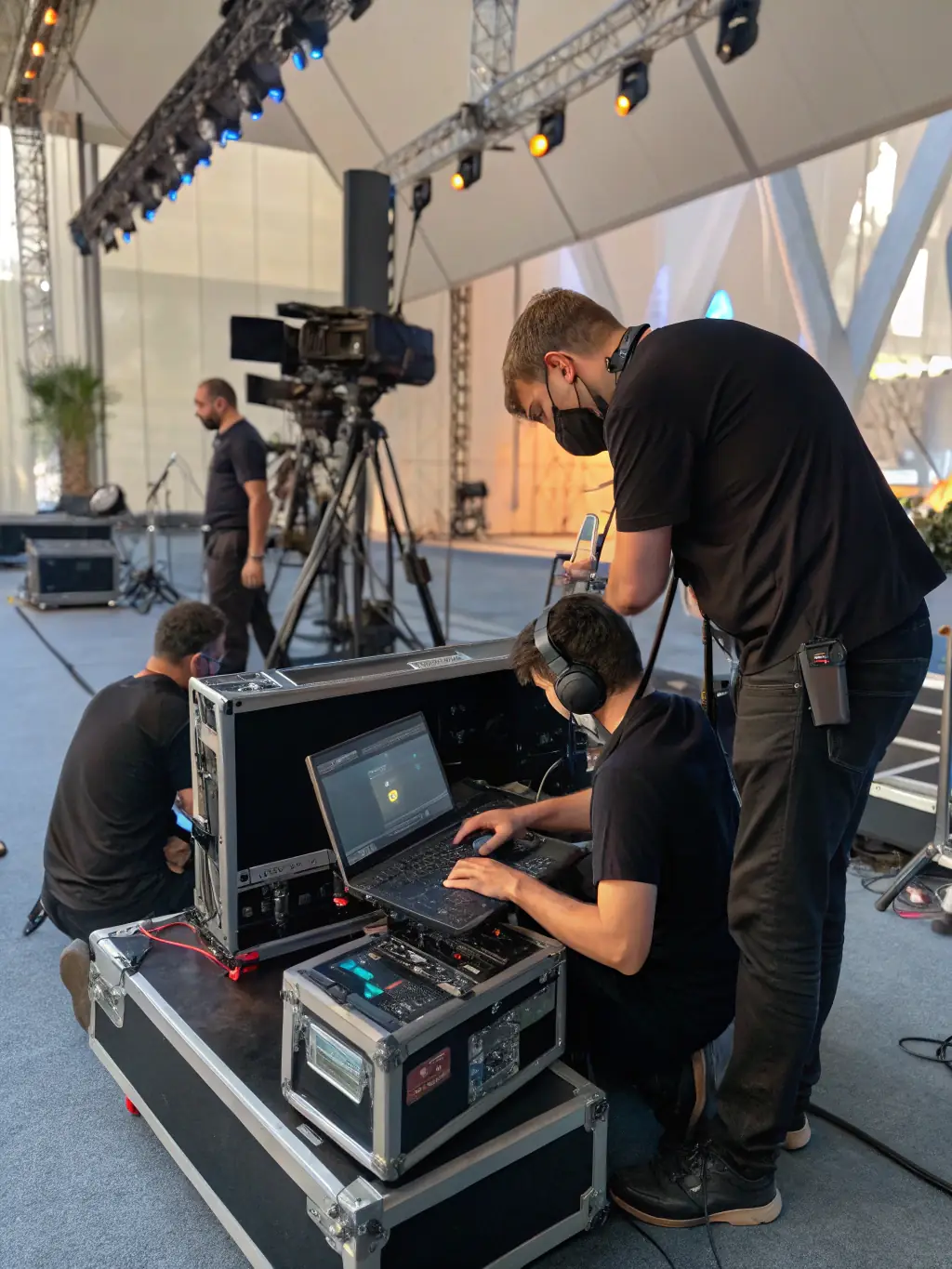 A behind-the-scenes image of technicians setting up equipment at a festival, highlighting the technical expertise ASS LA BOITE A MATOS provides.